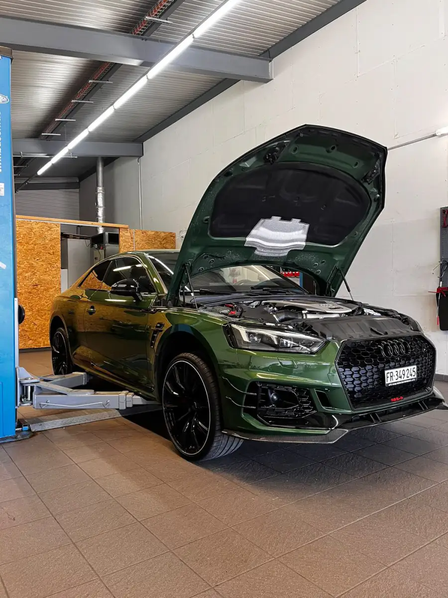 Véhicule au diagnostic, capot ouvert dans l'atelier