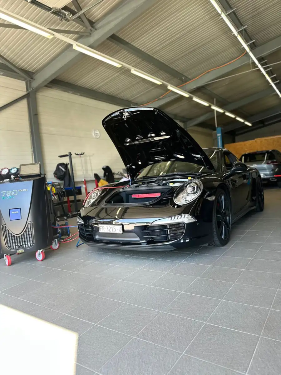 Voiture de sport capot ouvert dans l'atelier du Garage Bulliard